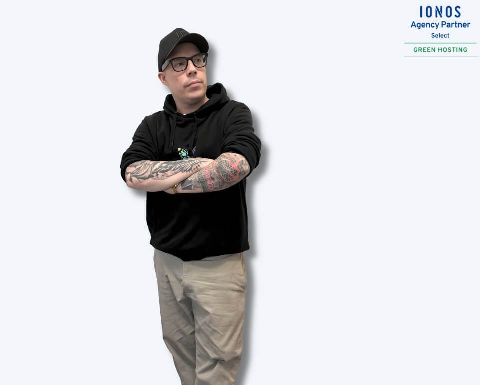 Dennis Dickmann von DigiAds44 Dennis von DigiAds44 mit verschränkten Armen vor hellem Hintergrund